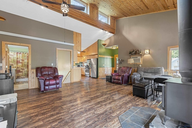 living room with ceiling fan, a towering ceiling, wood ceiling, and dark hardwood / wood-style flooring