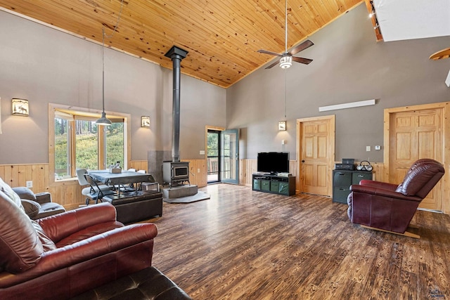 living room featuring high vaulted ceiling, dark wood-type flooring, wood ceiling, and a wood stove