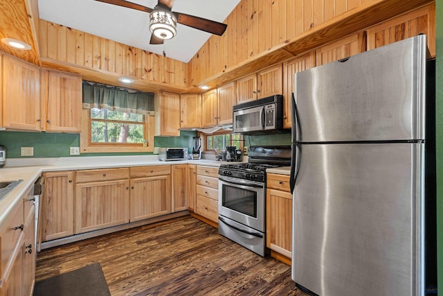 kitchen with light brown cabinetry, dark hardwood / wood-style floors, vaulted ceiling, ceiling fan, and stainless steel appliances