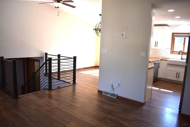 unfurnished room featuring vaulted ceiling, dark hardwood / wood-style flooring, sink, and ceiling fan