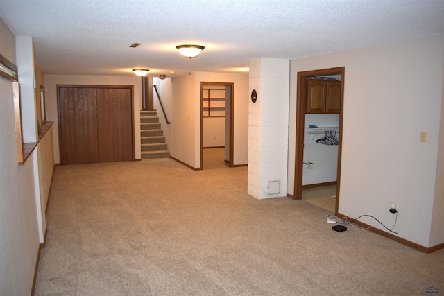 unfurnished room with light colored carpet and a textured ceiling