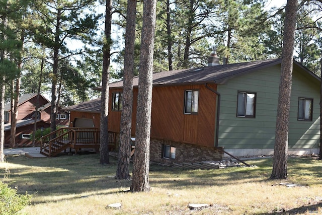 view of side of home featuring a lawn and a deck