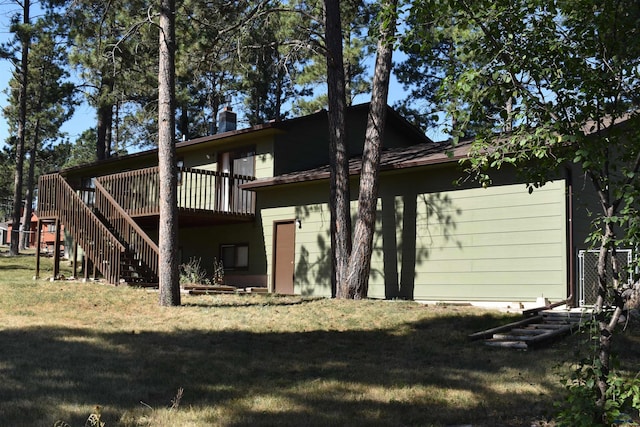 back of house with a wooden deck and a yard