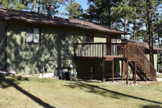 rear view of house featuring a lawn, a wooden deck, and central air condition unit