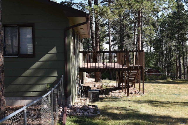 view of side of property with a yard, central AC, and a wooden deck