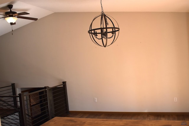 unfurnished room featuring ceiling fan with notable chandelier, wood-type flooring, and vaulted ceiling