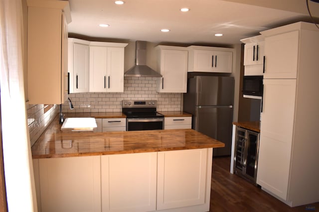 kitchen with butcher block counters, beverage cooler, decorative backsplash, wall chimney exhaust hood, and appliances with stainless steel finishes