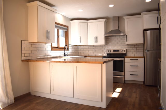 kitchen with dark wood-type flooring, decorative backsplash, stainless steel appliances, and wall chimney exhaust hood