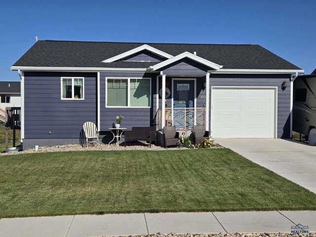 view of front of home featuring a front yard, outdoor lounge area, and a garage