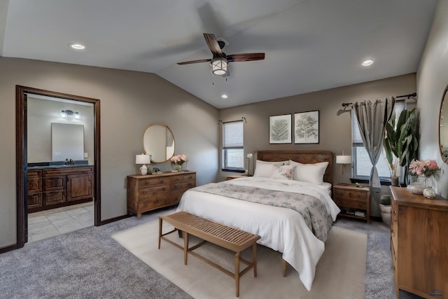 bedroom featuring ensuite bath, sink, ceiling fan, lofted ceiling, and light colored carpet