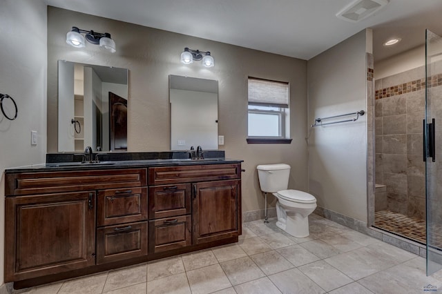 bathroom featuring vanity, toilet, tile patterned floors, and a shower with shower door