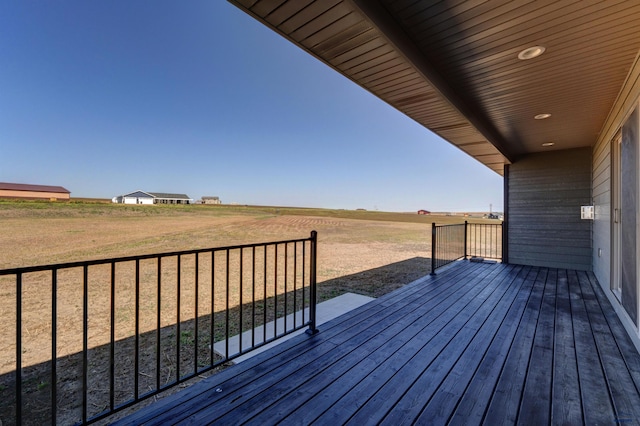 wooden deck featuring a yard and a rural view