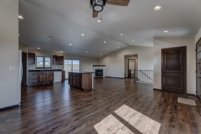 unfurnished living room featuring vaulted ceiling, dark hardwood / wood-style flooring, sink, and ceiling fan