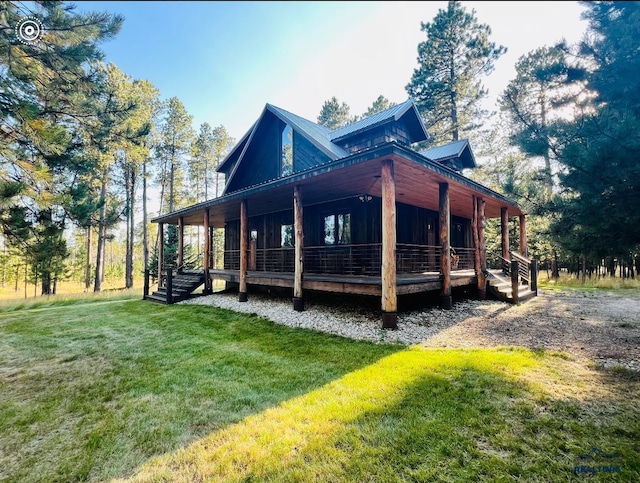 back of property featuring a porch, a lawn, and metal roof