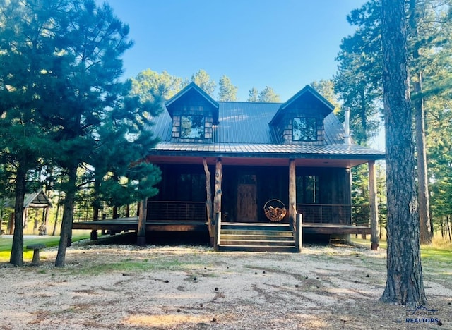 view of front of house featuring a standing seam roof, a porch, and metal roof