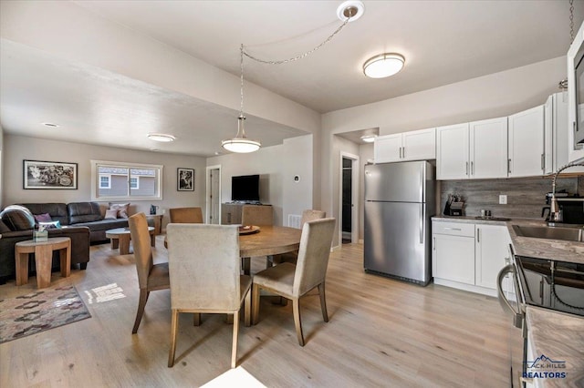 dining room with light hardwood / wood-style floors and sink