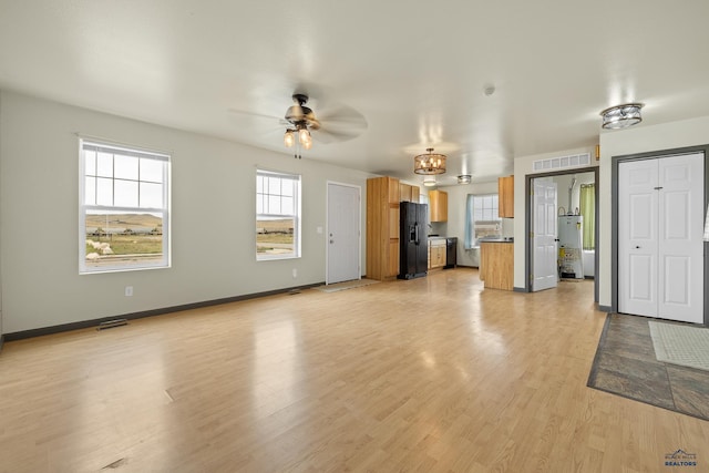 unfurnished living room featuring a wealth of natural light, ceiling fan, and light hardwood / wood-style floors