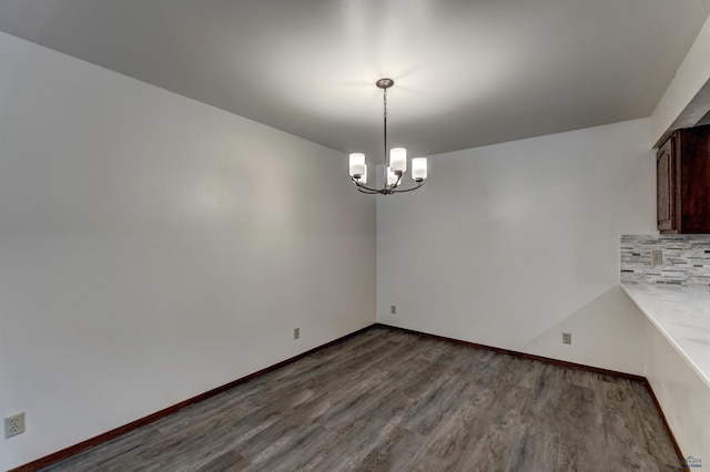 unfurnished dining area with a chandelier and hardwood / wood-style floors