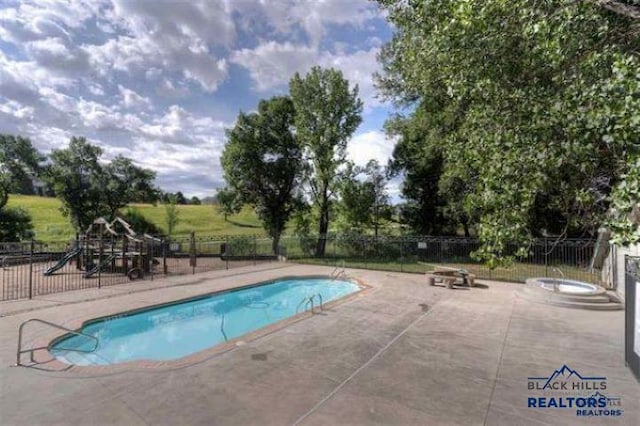 view of pool featuring a patio and a playground