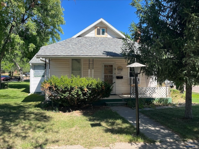 bungalow-style house featuring covered porch and a front yard