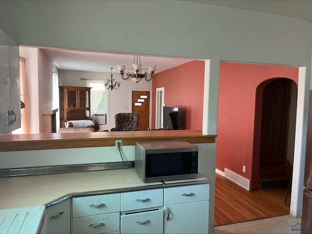 kitchen featuring a notable chandelier and wood-type flooring