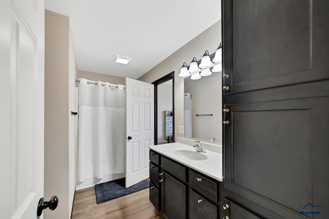 bathroom with a shower with curtain, wood-type flooring, and vanity