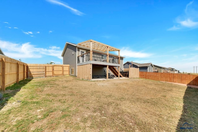 rear view of house with a wooden deck and a lawn