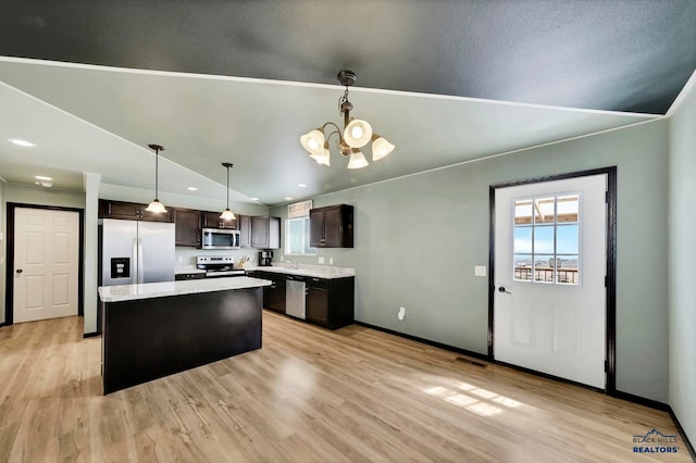 kitchen with a center island, dark brown cabinets, light hardwood / wood-style flooring, and stainless steel appliances