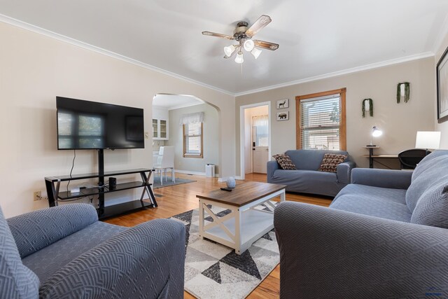 living room featuring crown molding, light hardwood / wood-style flooring, and ceiling fan