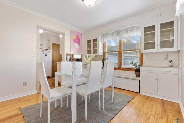 dining area featuring crown molding and light hardwood / wood-style floors