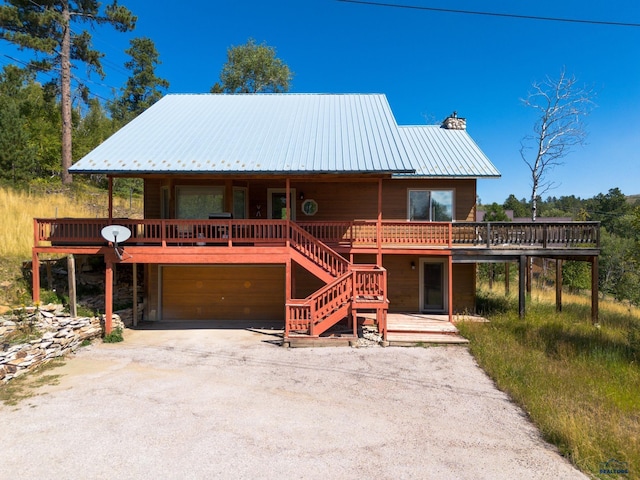 21169 Last Chance Trl, Lead, SD 57754 - chalet / cabin featuring a chimney, metal roof, an attached garage, a wooden deck, and stairs