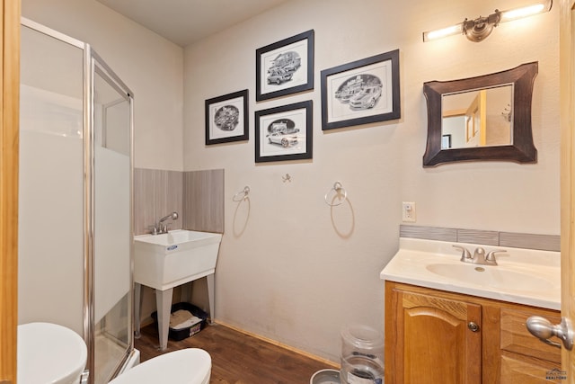 bathroom featuring vanity, toilet, hardwood / wood-style floors, and walk in shower