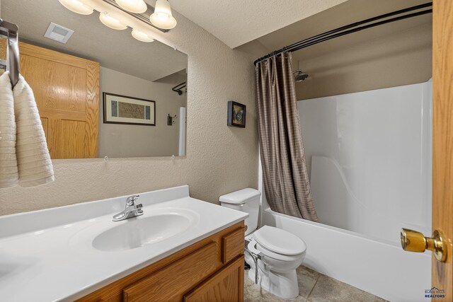 full bathroom featuring tile patterned flooring, toilet, shower / bath combination with curtain, vanity, and a textured ceiling