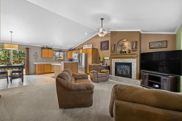 tiled living room featuring lofted ceiling, ceiling fan, ornamental molding, and a tile fireplace