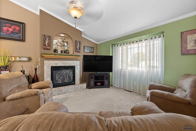 carpeted living room with lofted ceiling, crown molding, ceiling fan, and a fireplace