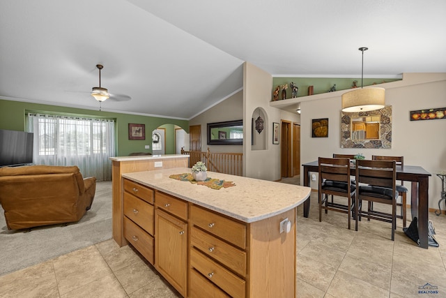 kitchen featuring pendant lighting, crown molding, a center island, ceiling fan, and lofted ceiling