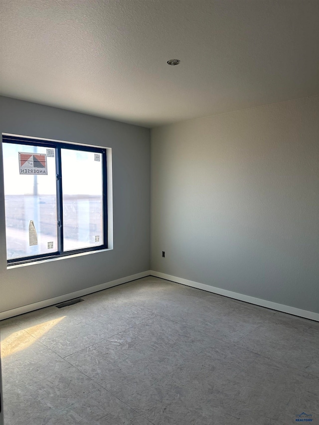 spare room with a textured ceiling