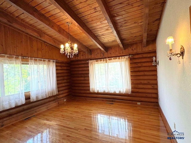 spare room featuring plenty of natural light, wood-type flooring, a chandelier, and lofted ceiling with beams