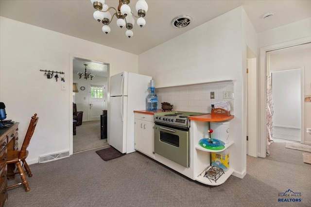 kitchen featuring carpet floors, a chandelier, white fridge, and stainless steel electric range