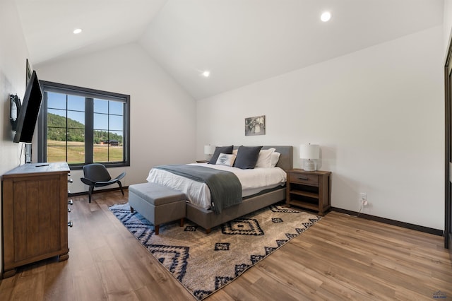 bedroom featuring light wood-type flooring and vaulted ceiling