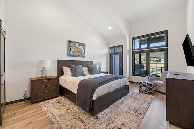 bedroom featuring high vaulted ceiling and light wood-type flooring