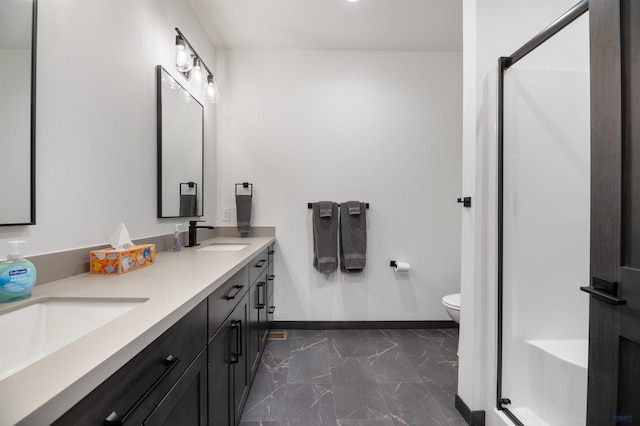 bathroom featuring vanity, toilet, and a shower with door