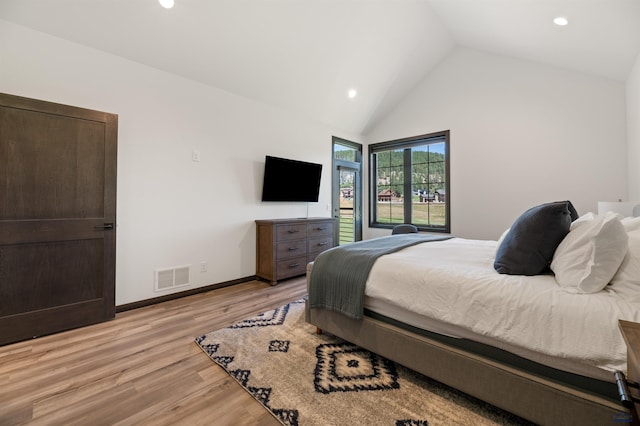 bedroom featuring lofted ceiling and light hardwood / wood-style floors