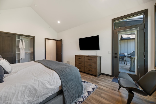 bedroom featuring light hardwood / wood-style flooring, vaulted ceiling, and a closet