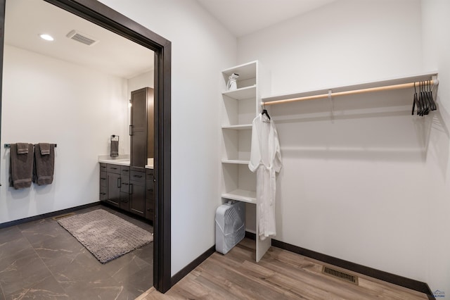 spacious closet featuring dark hardwood / wood-style flooring