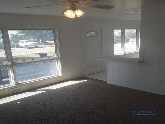 empty room featuring carpet floors and ceiling fan