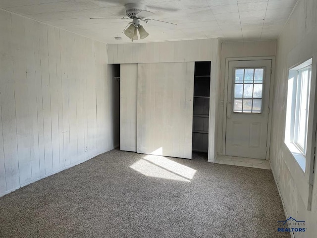 1022 Blaine Ave, Rapid City, SD 57701 - unfurnished bedroom with a closet, carpet flooring, ceiling fan, and wooden walls