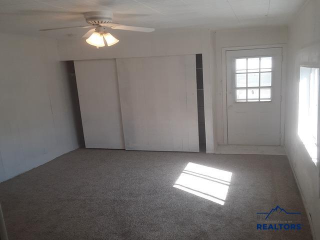 carpeted empty room with ceiling fan