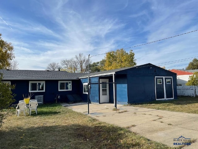 1022 Blaine Ave, Rapid City, SD 57701 - rear view of house featuring concrete block siding, a lawn, and fence