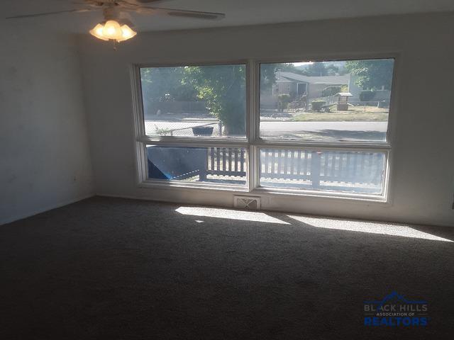 empty room with carpet and ceiling fan